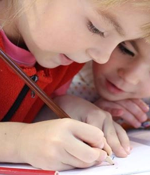 Two kids studying in singapore random schools with pencil in hand 